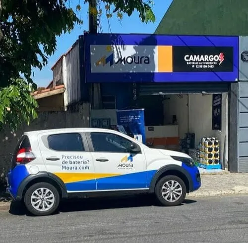 Fachada da Camargo Baterias no Jardim Satélite, com o carro da Moura estacionado na frente